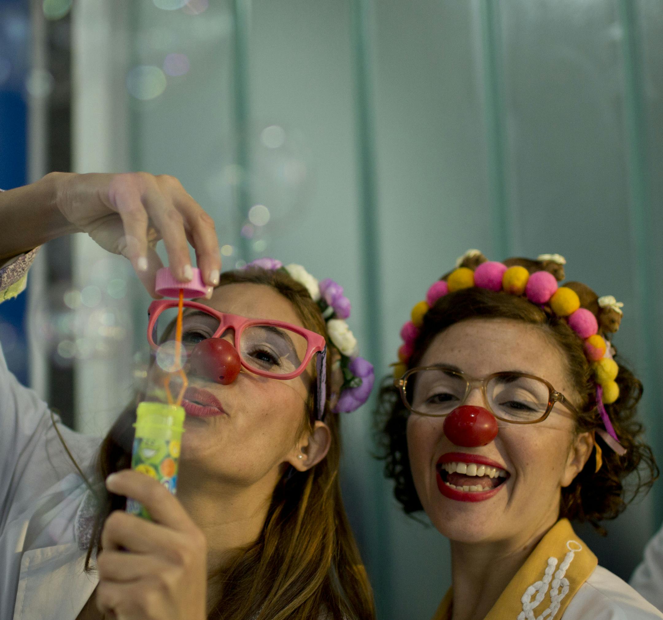 Clowns Erika Veliz, left, blows bubbles and Romina Amato, smile as they say their goodbyes to children hospitalized at a pediatric hospital in Buenos Aires, Argentina, Thursday, June 4, 2015. Tapping into the healing power of laughter, a new law in the province of Buenos Aires makes it obligatory that children’s hospitals provide specially trained clowns as part of their health care facilities. (AP Photo/Natacha Pisarenko)