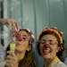 Clowns Erika Veliz, left, blows bubbles and Romina Amato, smile as they say their goodbyes to children hospitalized at a pediatric hospital in Buenos 