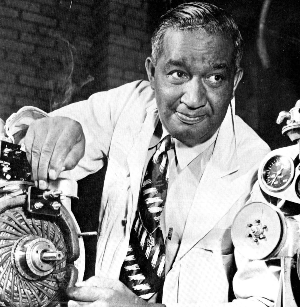 Frederick McKinley Jones with a component of a refrigeration unit that he designed.