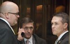 FILE -- Michael Flynn, center, who on Feb. 13, 2017 resigned his position as President Trump's national security adviser, on an elevator in the lobby 