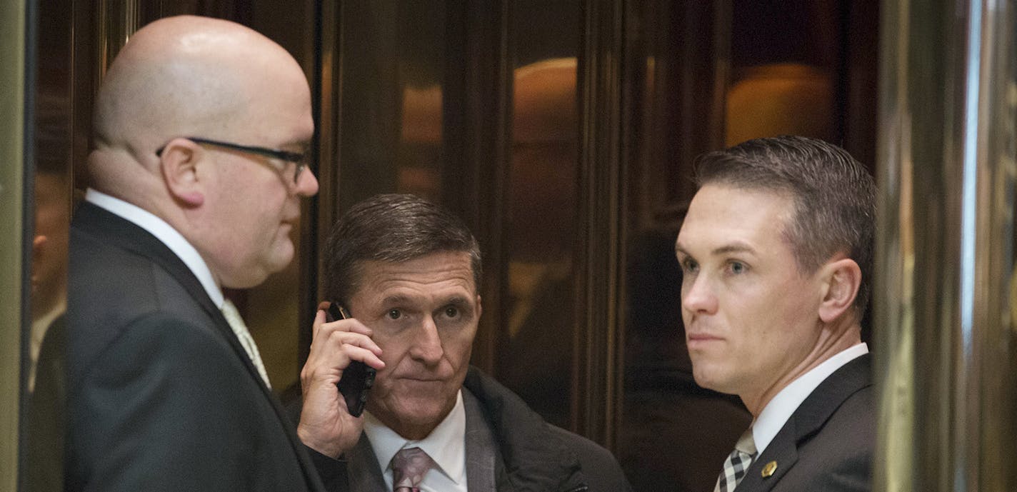 FILE -- Michael Flynn, center, who on Feb. 13, 2017 resigned his position as President Trump's national security adviser, on an elevator in the lobby of Trump Tower on Fifth Avenue in New York, Jan. 12, 2017. The resignation is fueling the notion by some Russian lawmakers that Russophobia is again stalking the corridors of power in Washington. (Kevin Hagen/The New York Times) ORG XMIT: MIN2017021410402508