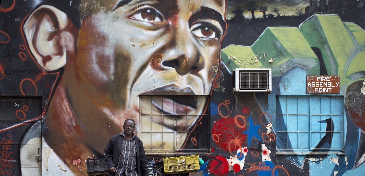 A man walks away after leaning his bicycle against a mural of President Barack Obama, created by the Kenyan graffiti artist Bankslave, at the GoDown Arts Centre in Nairobi, Kenya Wednesday, July 22, 2015. In his first trip to Kenya since he was a U.S. senator in 2006, Obama is scheduled to arrive in Kenya on Friday, the first stop on his two-nation African tour in which he will also visit Ethiopia. (AP Photo/Ben Curtis) ORG XMIT: ABC101