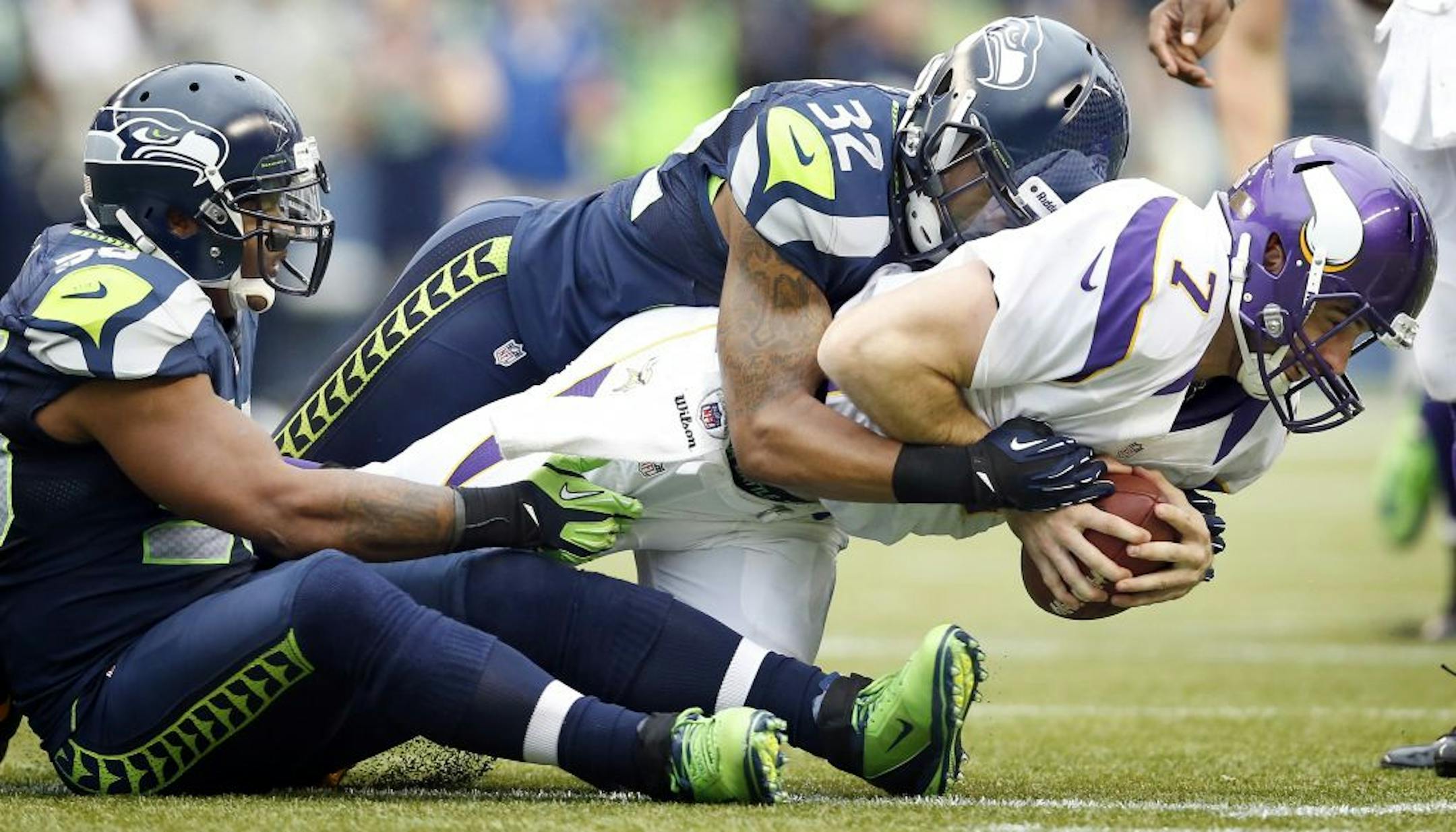 Vikings quarterback Christian Ponder (7) was finished off by Jeron Johnson (32) after being sacked by Leroy Hill (56) and Bruce Irvin (51) in the third quarter. Seattle beat Minnesota by a final score of 30-20.