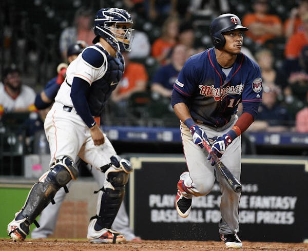 Minnesota Twins' Jorge Polanco, right, watches his two-run home run off Houston Astros relief pitcher Chris Devenski during the eighth inning of a bas