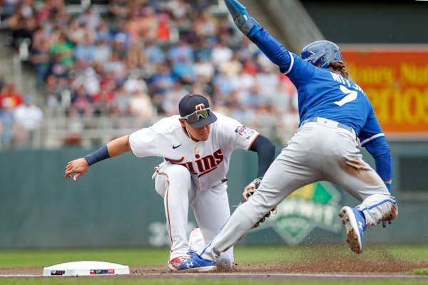 Minnesota Twins third baseman Gio Urshela, left, tags out Kansas City Royals' Bobby Witt on a fielder's choice hit by Salvador Perez in the first inni