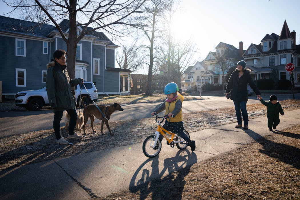 Maiya Papach, left, and Rebecca Albers, who hold principal viola chairs in their respective orchestras, walk with their two kids and two dogs to a park near their St. Paul home.