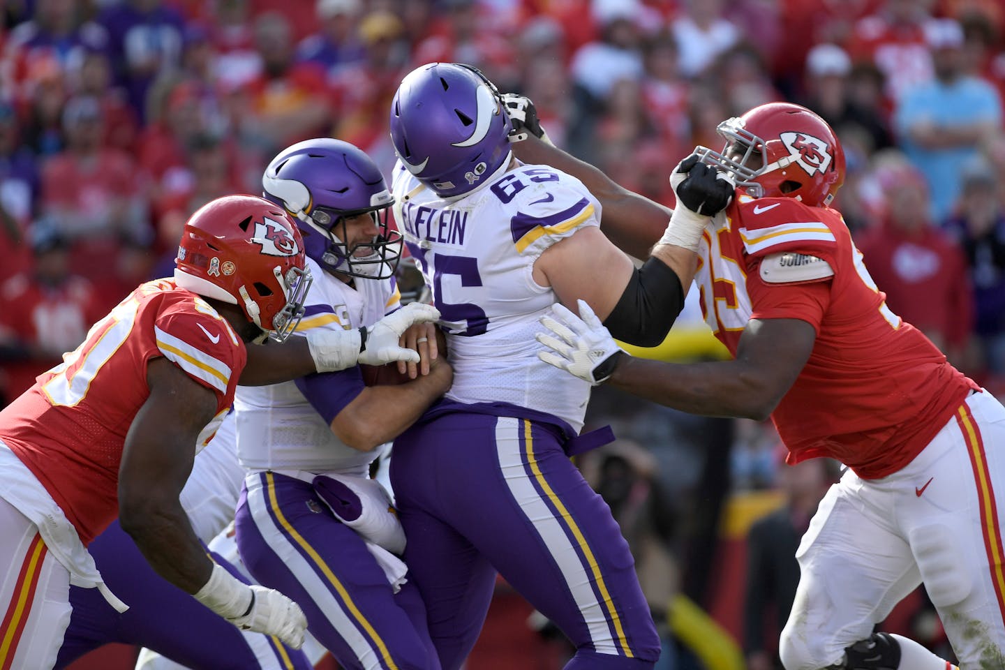 Kansas City defensive end Emmanuel Ogbah, left, sacks Vikings quarterback Kirk Cousins as guard Pat Elflein blocks Chris Jones.