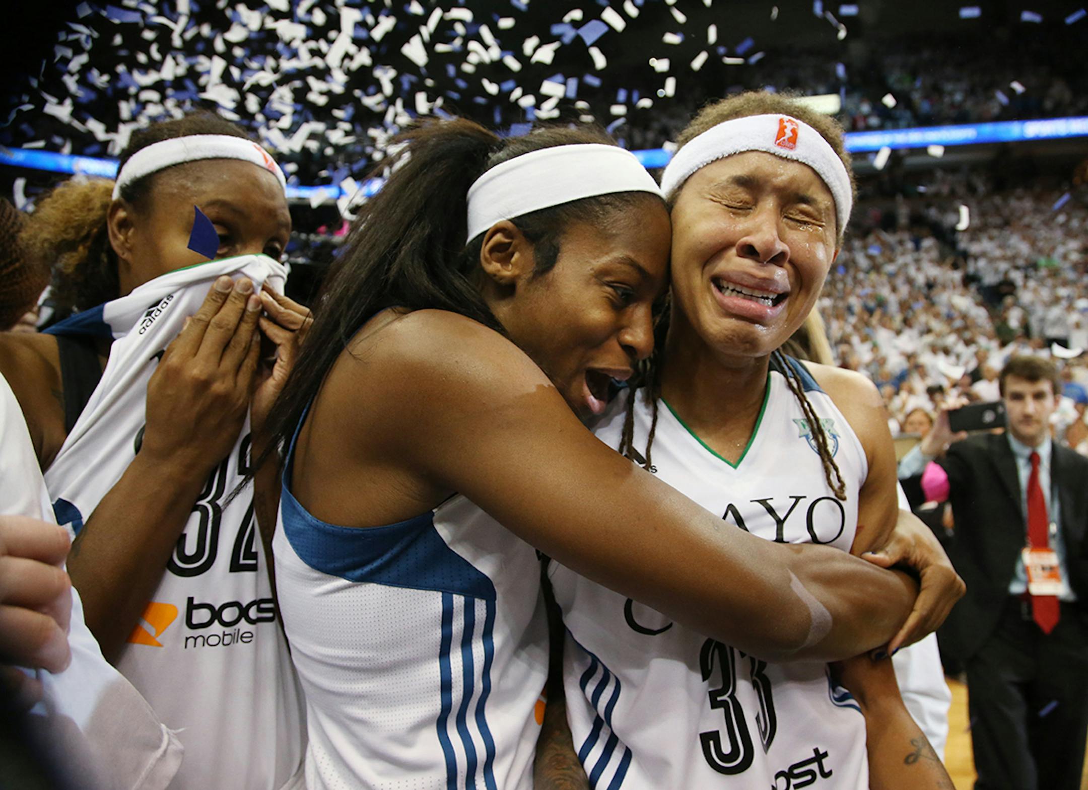 Minnesota Lynx guard Seimone Augustus (33), right, and Minnesota Lynx forward Devereaux Peters (14) celebrate winning the WNBA title.