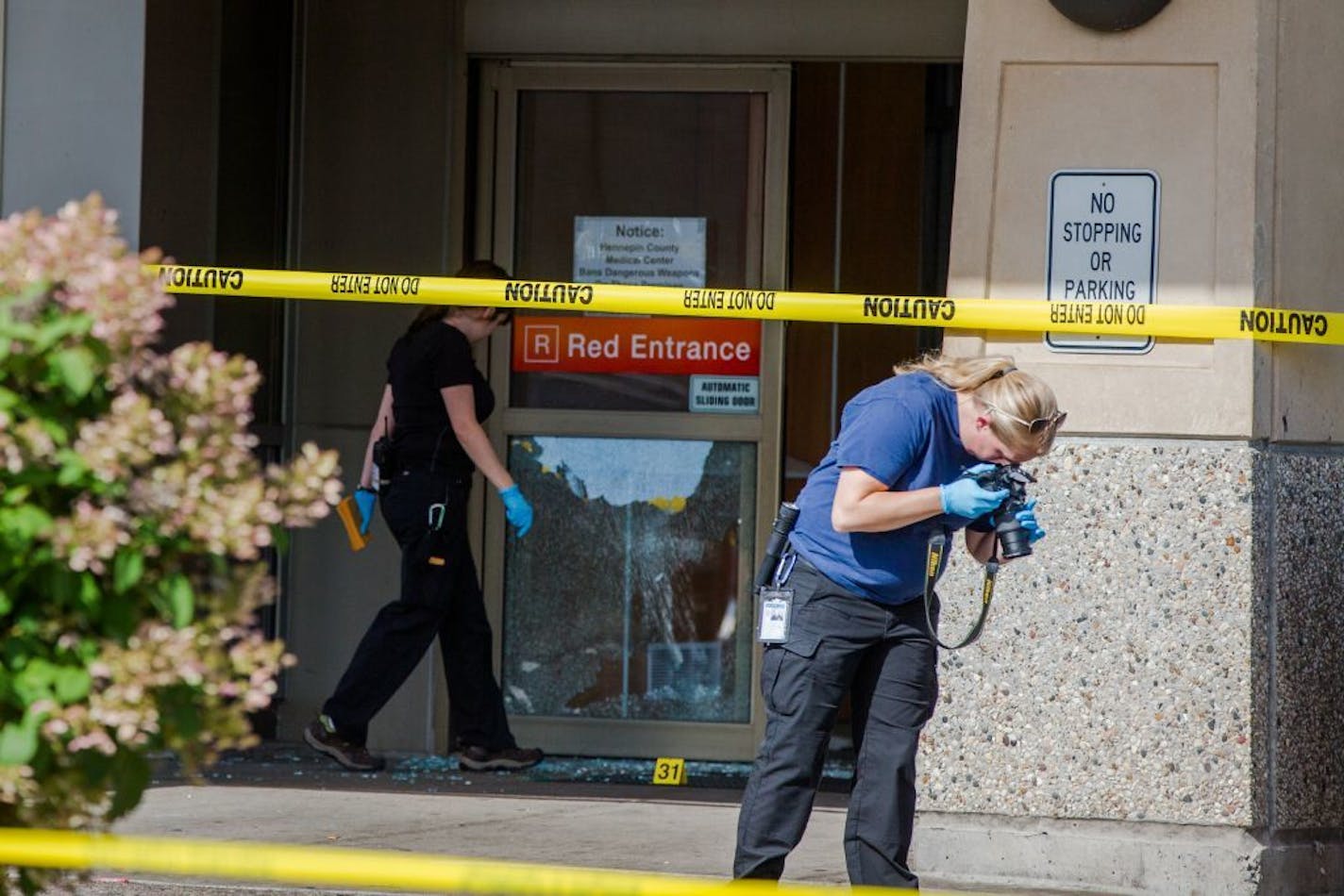 HCMC082714 * Mark Vancleave - mark.vancleave@startribune.com * Minneapolis police investigated shots that were fired at Hennepin County Medical Center in downtown Minneapolis on Tuesday afternoon.on Tuesday, Aug. 26, 2014. [Police inspect damage to HCMC South 8th Street enterence.