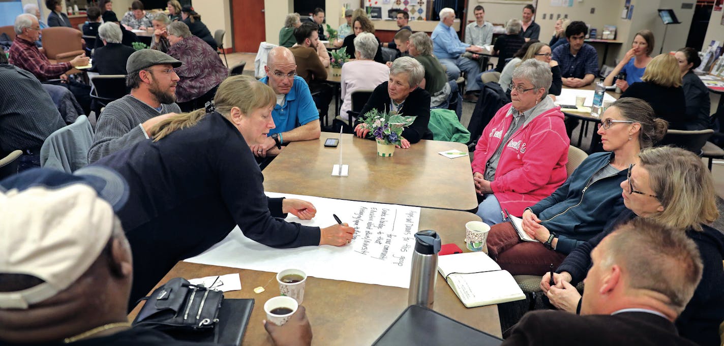 The first meeting of the task force drew more than 50 people on a rainy weeknight. Breaking into small groups, participants shared their experiences with racism, sexism and homophobia. Here, Chris Brazelton writes down the hopes and dreams of her group. (Brazelton is married to Larry Brazelton (bottom left), one of the few people of color in Delano.