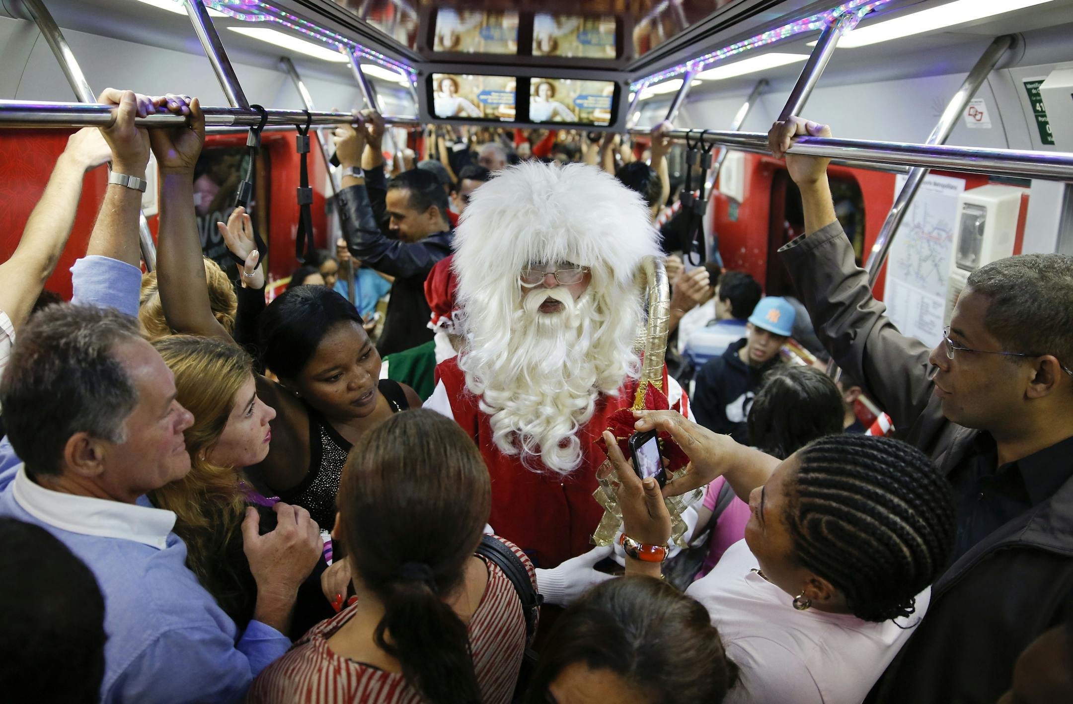 A man dressed as Santa Claus rides a crowded subway train in Sao Paulo, Brazil, Friday, Dec. 5, 2014. This Santa says he'll ride the city's subway trains this month to celebrate the Christmas season.