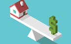 iStock
Isometric small house and green dollar sign on weight scales. Balance, price, real estate and home concept.