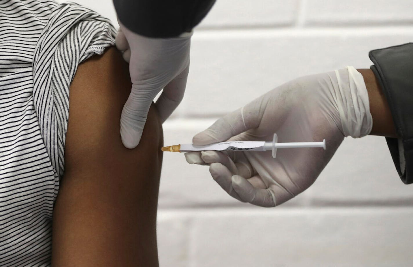 In this Wednesday, June 24, 2020 file photo, a volunteer receives an injection at the Chris Hani Baragwanath hospital in Soweto, Johannesburg, as part of Africa's first participation in a COVID-19 vaccine trial developed at the University of Oxford in Britain in conjunction with the pharmaceutical company AstraZeneca. On Friday, Oct. 23, 2020, AstraZeneca Inc. announced that the Food and Drug Administration is letting it resume testing of its COVID-19 vaccine candidate in the U.S. (Siphiwe Sibek