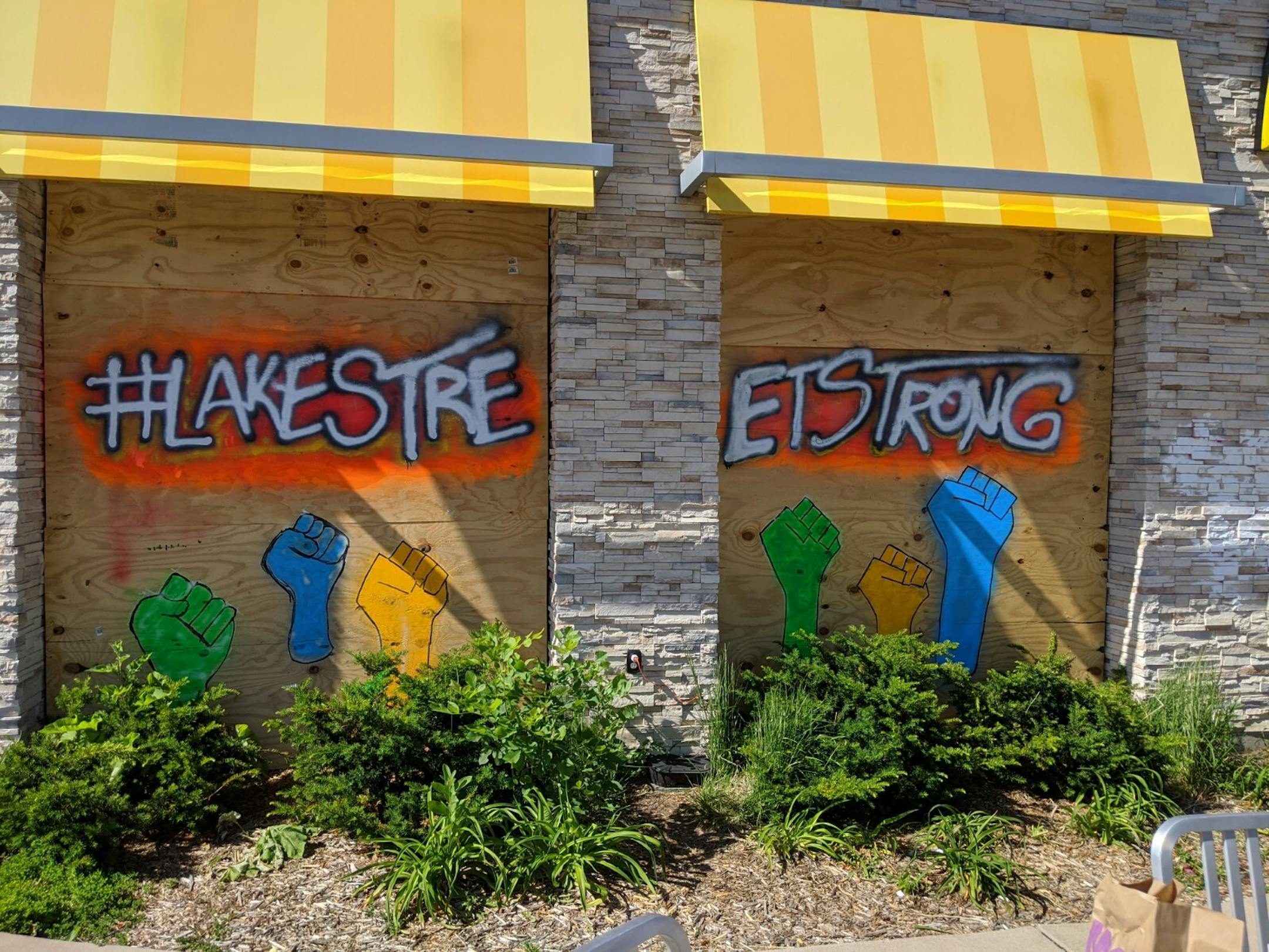 Neighborhood solidarity messages dominate the boarded-up windows of McDonald's at 3110 E Lake St., which is across from a Walgreens that was destroyed by fire following riots.
