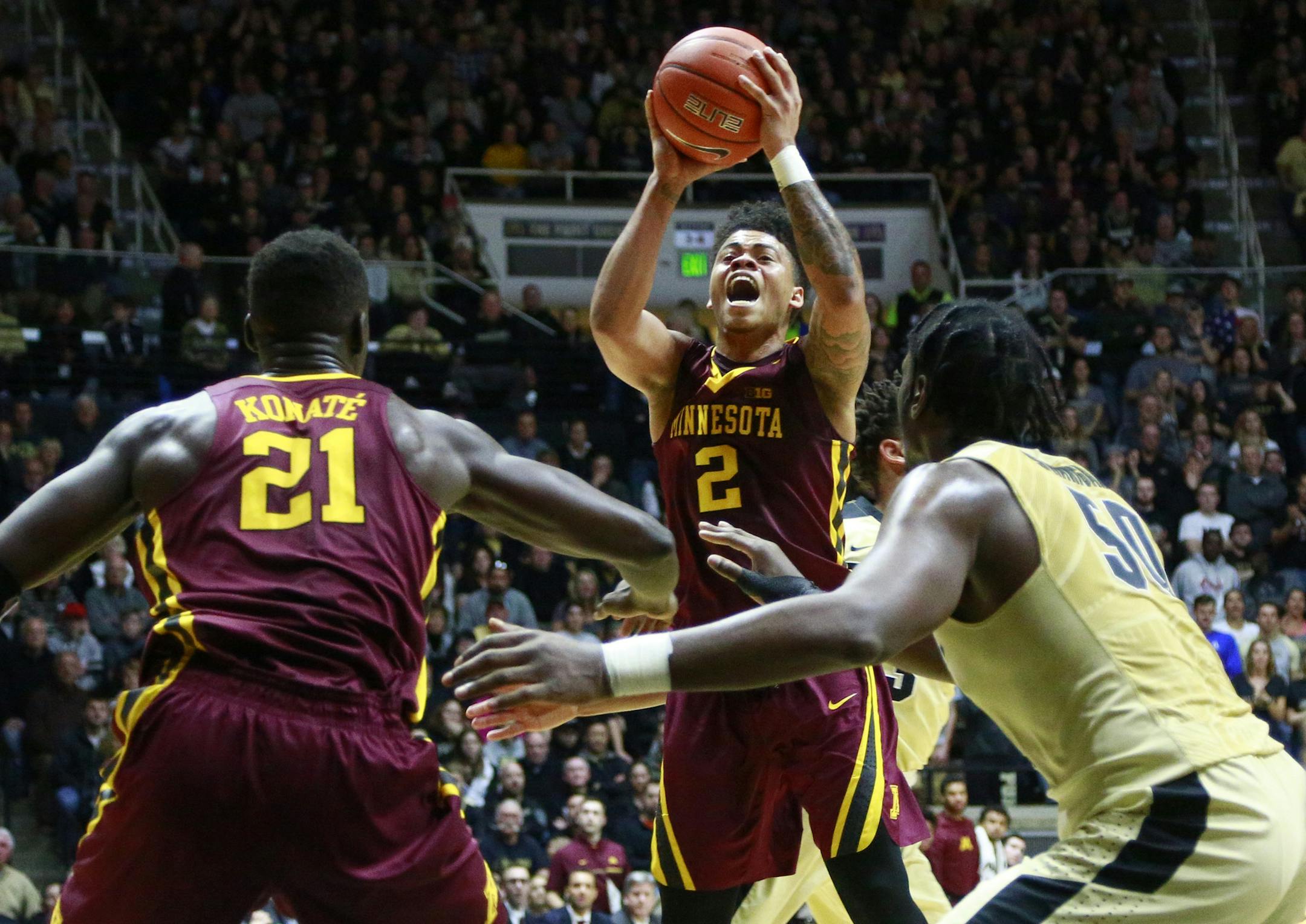 Minnesota guard Nate Mason (2) shoots in front of Minnesota center Bakary Konate (21) and Purdue forward Caleb Swanigan in the first half of an NCAA college basketball game, Sunday, Jan. 1, 2017, in West Lafayette, Ind. (AP Photo/R Brent Smith)