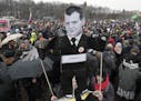 Protesters hold a cardboard cutout poster depicting Russian Prime Minister Dmitry Medvedev at Marsivo Field in St.Petersburg, Russia, Sunday, March 26
