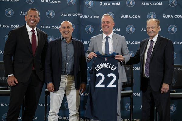 Wolves president Tim Connelly held a jersey, flanked by owners Alex Rodriguez, Marc Lore and Glen Taylor, at his introductory news conference.