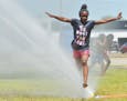 Serena Porter, 9, stays cool as she runs through water provided by the Benton Harbor Department of Public Safety during Spray and Play on Tuesday, Jun