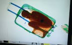 In this photo released by the Spanish Guardia Civil on Friday, May 8, 2015, a boy curled up inside a suitcase is seen on the display of a scanner at t