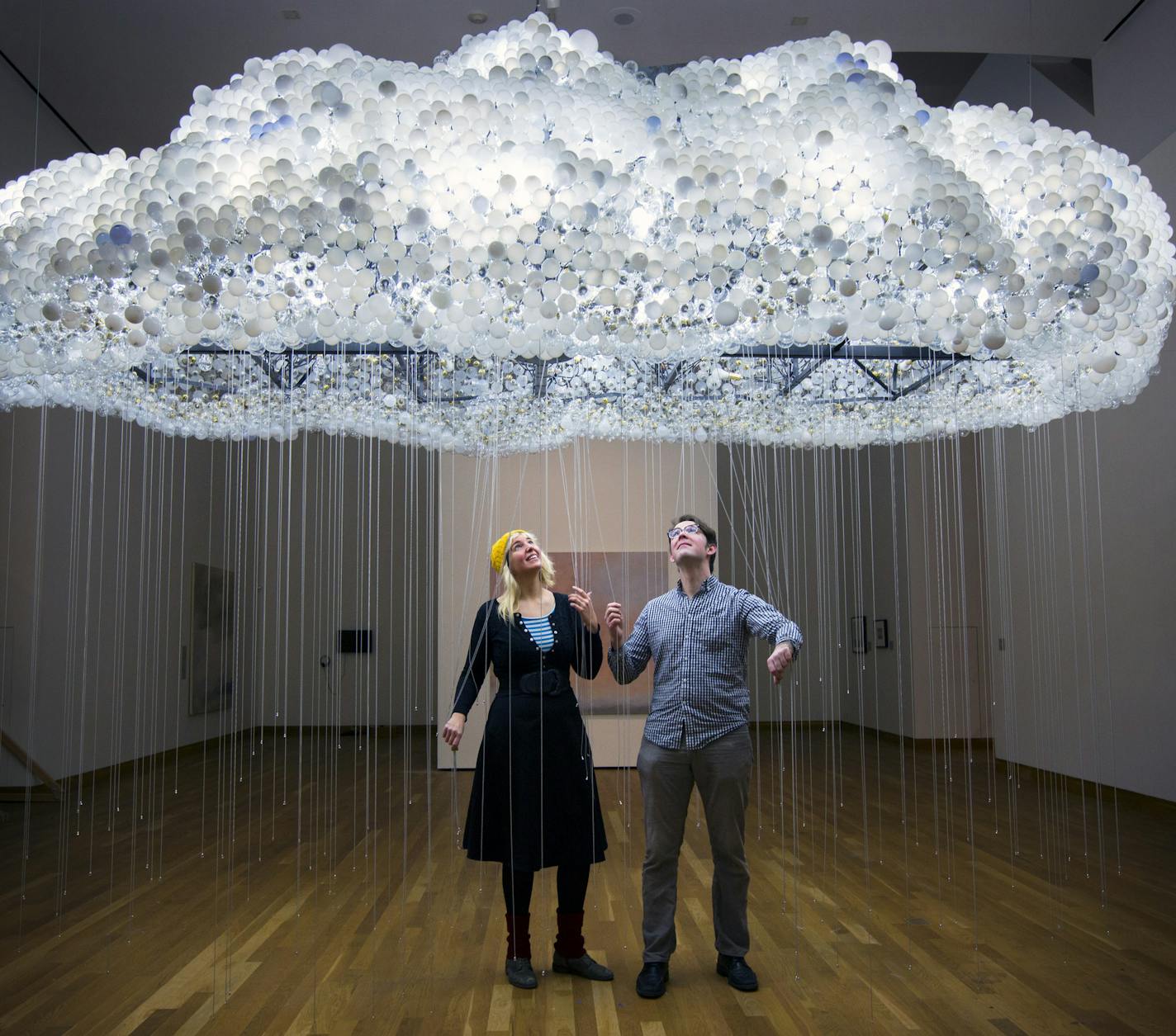 Caitlind r.c. Brown and Wayne Garrett beneath their "Cloud," made up of thousands of bulbs that viewers can illuminate by pulling the cords.