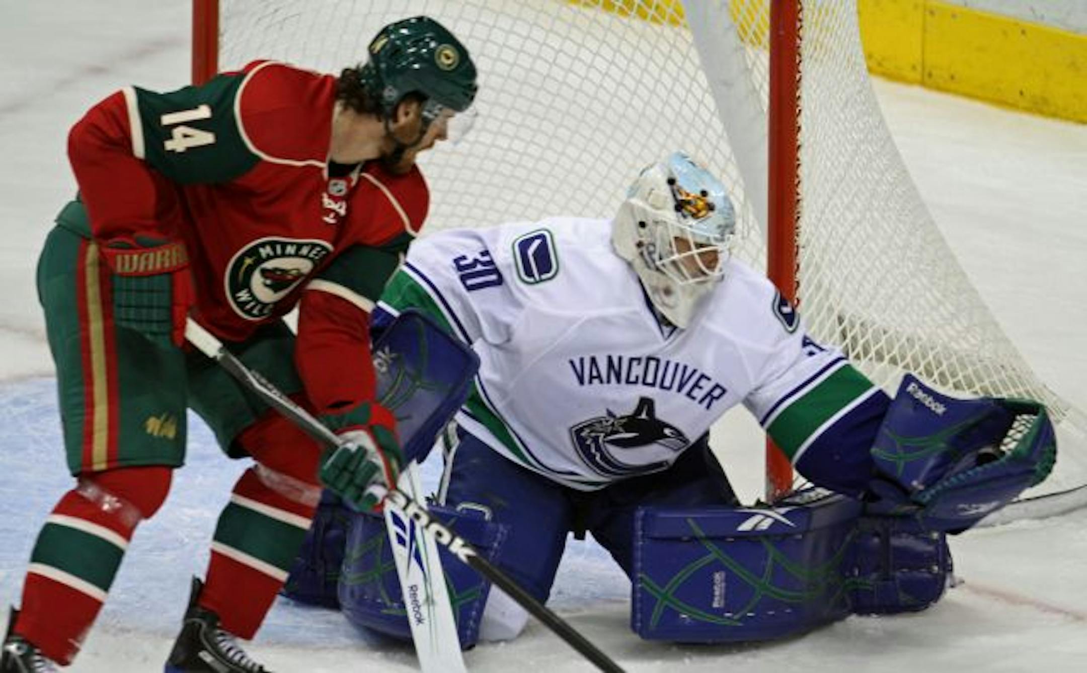 Minnesota Wild vs. Vancouver. (left to right) Wild's Martin Havlat crashed the net as Vancouver goalie Andrew Raycroft scooped up the shot on goal in first period action.