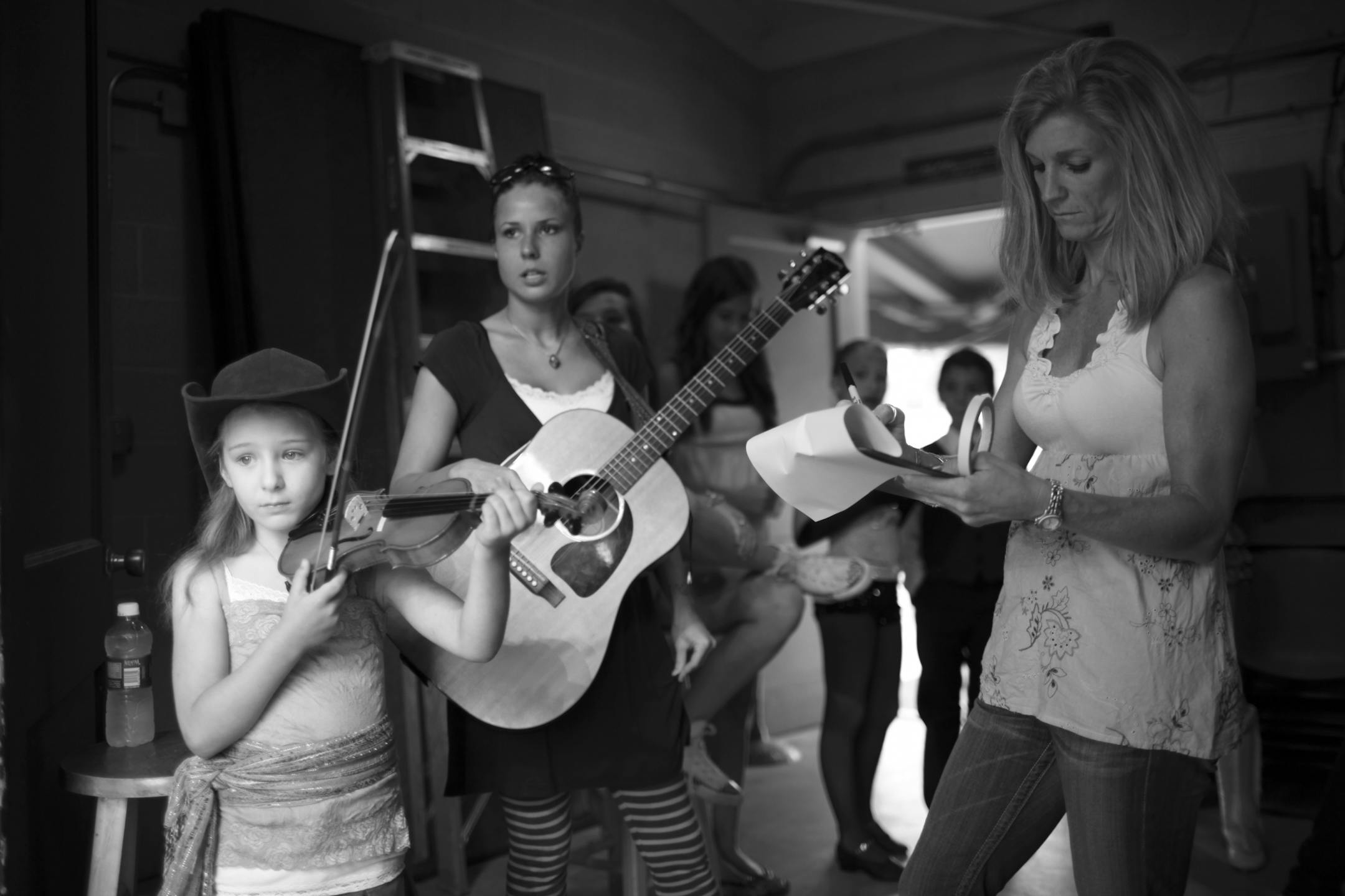 Madelin Beckwith, 6, warmed up on her violin while she waited to walk on stage to audition in the pre-teen competition category Thursday evening. She was with her teacher, Deena Bistodeau, who accompanied her on guitar.