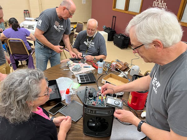 Anna Beal, left, watches as volunteer Dave Purdham works on her 20-year-old air purifier. For more than a decade, volunteers have provided free repair