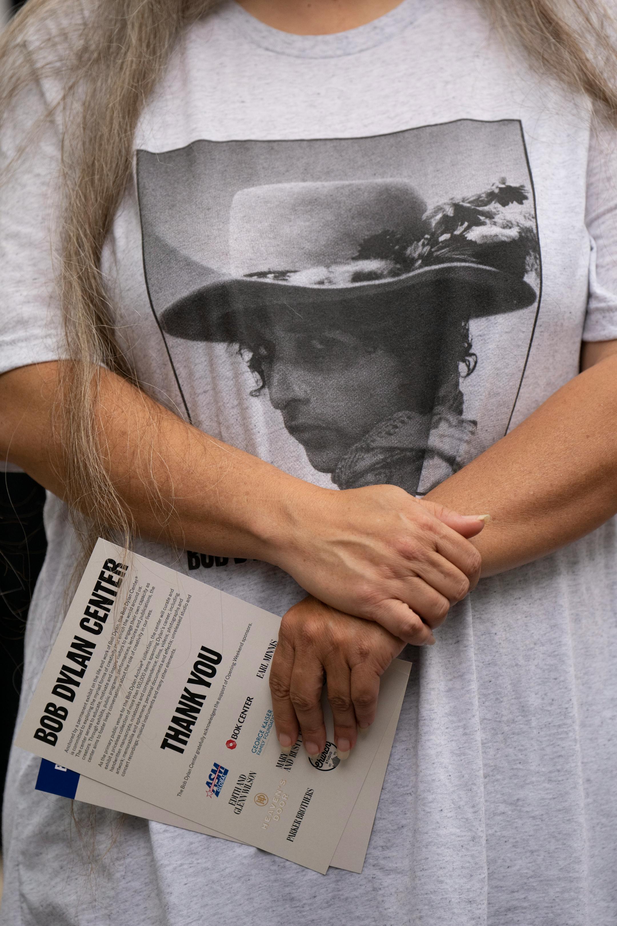 A fan listened to a speaker on the program during the ribbon-cutting ceremony to open the Bob Dylan Center in Tulsa, Okla. on Tuesday, May 10, 2022.