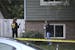 Members of the Bureau of Criminal Apprehension gather information at the house where three people were found dead in Oakdale Minn., Thursday, Septembe