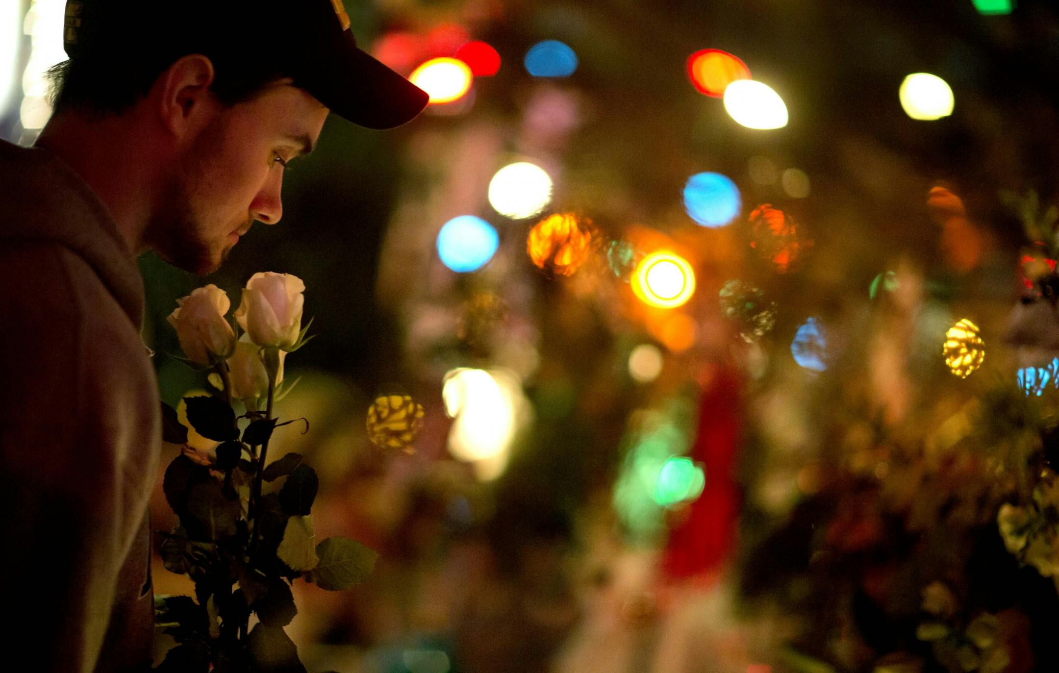 Newtown resident, who identified himself only as Andrew, holds roses as he visits a memorial for the Sandy Hook Elementary School shooting victims, Tuesday, Dec. 18, 2012, in Newtown, Conn.