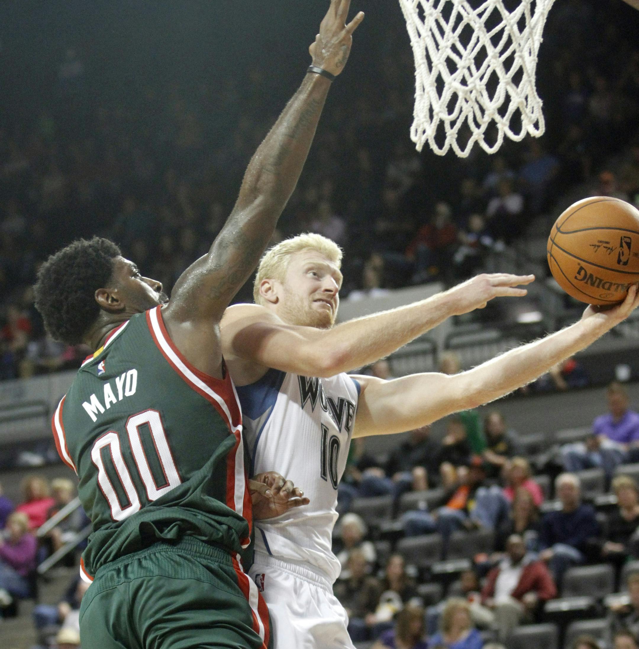 Minnesota Timberwolves forward Chase Budinger, right, drives to the basket past Milwaukee Bucks guard O.J. Mayo during the second half of a preseason NBA basketball game, Friday, Oct. 17, 2014, in Cedar Rapids, Iowa. (AP Photo/Matthew Holst)