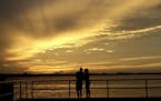 A couple is silhouetted against the sunset at the St. Andrews Marina in Panama City, Fla., Tuesday, Oct. 9, 2018, ahead of Hurricane Michael.