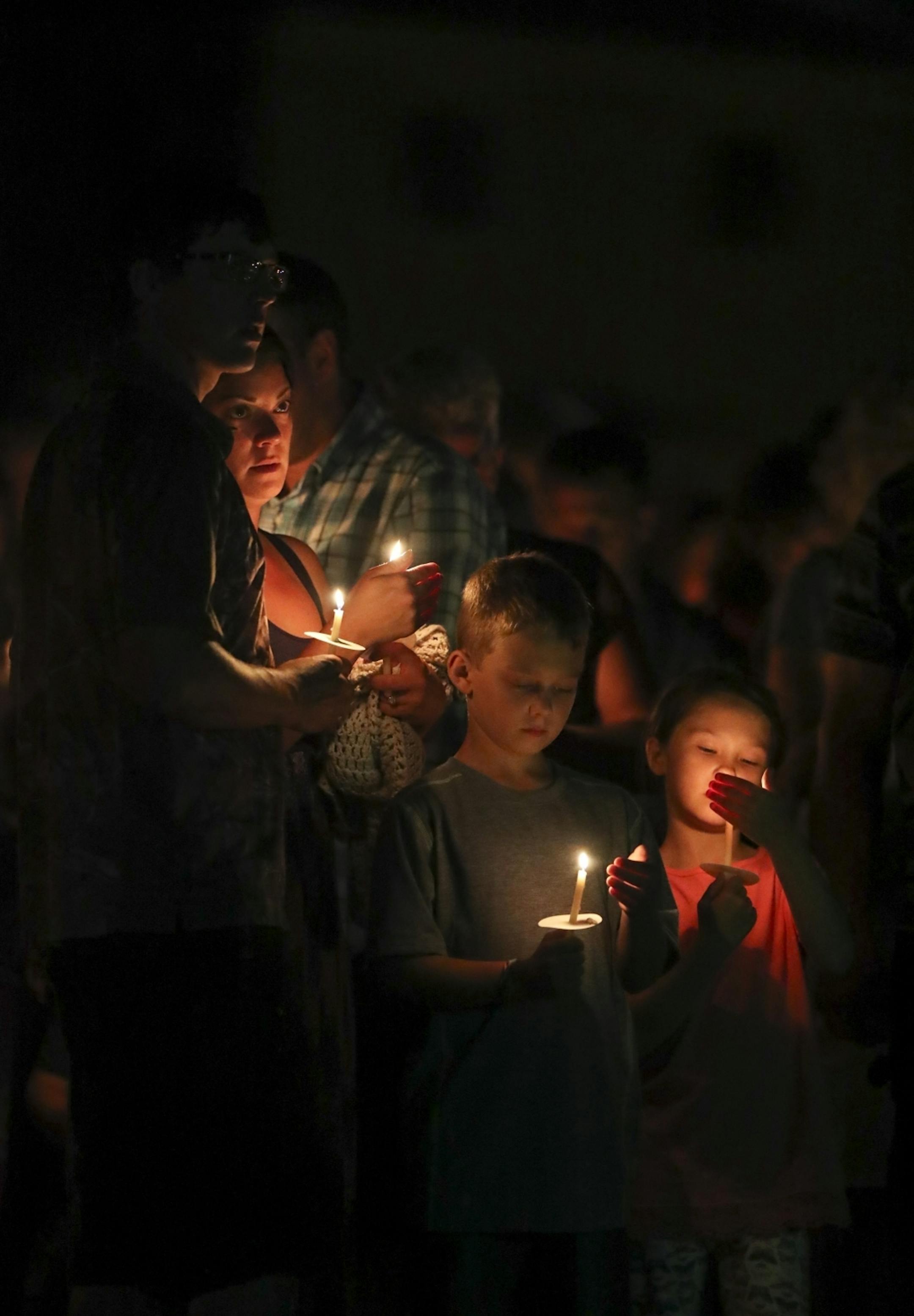 Matt and Kayla, the parents of Alayna Ertl, stood with their lit candles during the prayer vigil for their daughter Tuesday night in the parking lot of St. Anthony Church in Watkins.