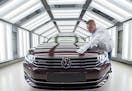 A worker checks a Passat Variant car during a press tour at the plant of the German manufacturer Volkswagen Sachsen in Zwickau, Germany.