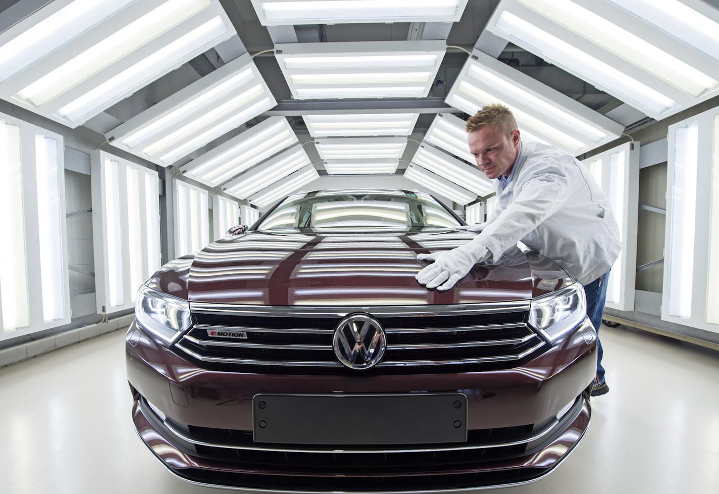 A worker checks a Passat Variant car during a press tour at the plant of the German manufacturer Volkswagen Sachsen in Zwickau, Germany.