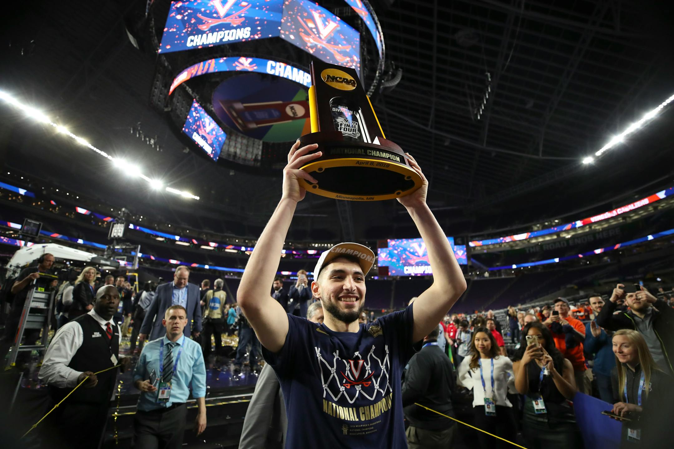 Virginia guard Ty Jerome hoisted the championship trophy aloft as he walked off the court after Monday's victory at U.S. Bank Stadium.