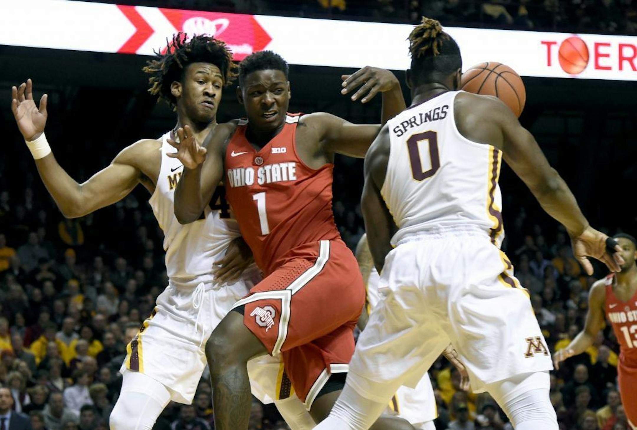 Minnesota guard Akeem Springs (0) strips the ball from Ohio State forward Jae'Sean Tate (1) while Minnesota forward Eric Curry (24) defends during the first half of an NCAA college basketball game Sunday, Jan. 8, 2017, in Minneapolis. Minnesota won 78-68.