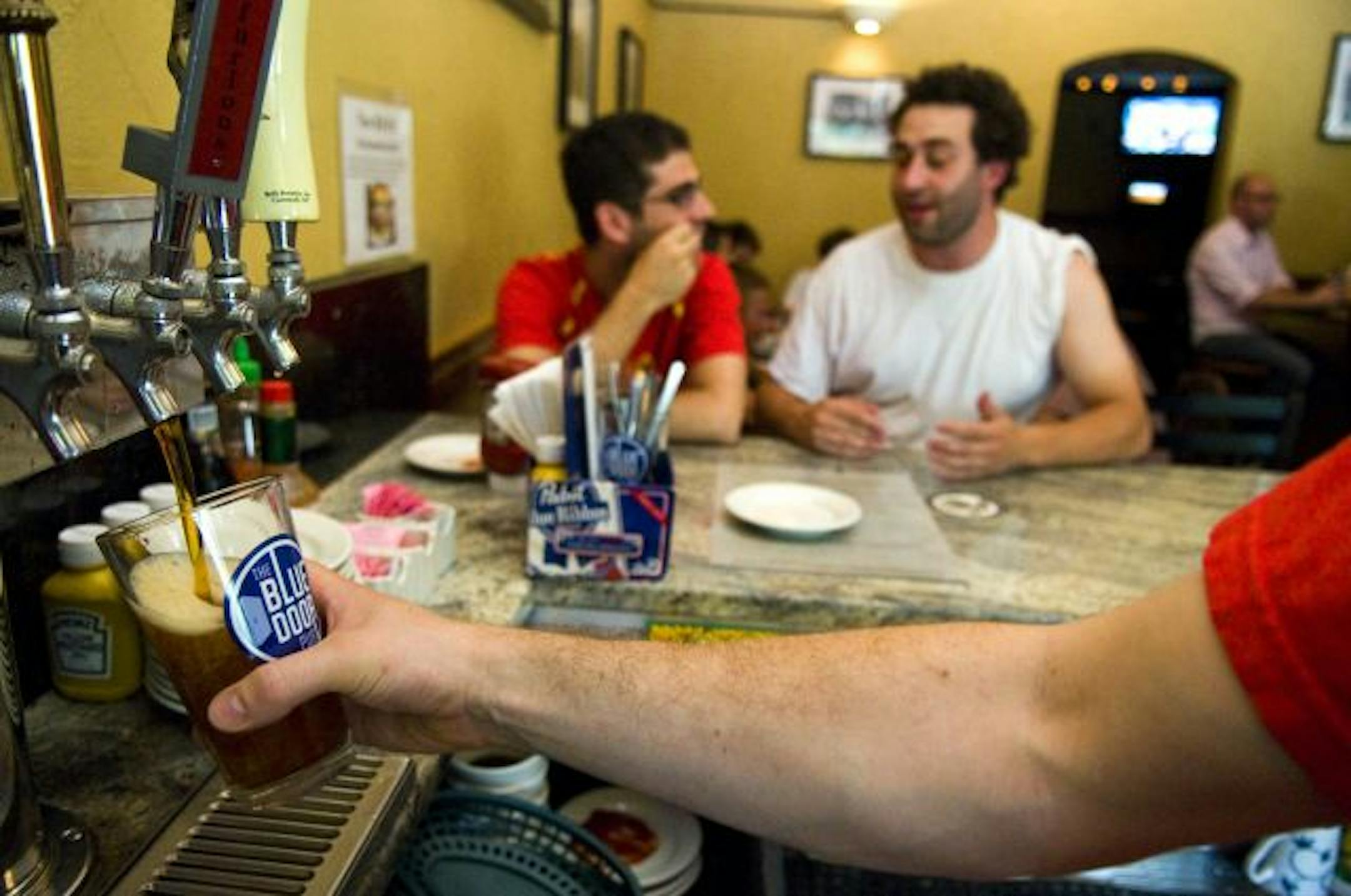 Bartender Tyson Wigley poured a Surly Furious during happy hour Monday at the Blue Door Pub in St. Paul.