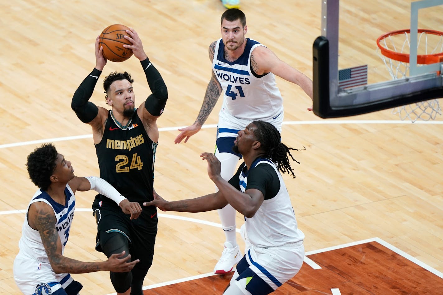 Memphis' Dillon Brooks drives against the Timberwolves' Jaden McDaniels (3), Juancho Hernangomez (41) and Naz Reid in the first half