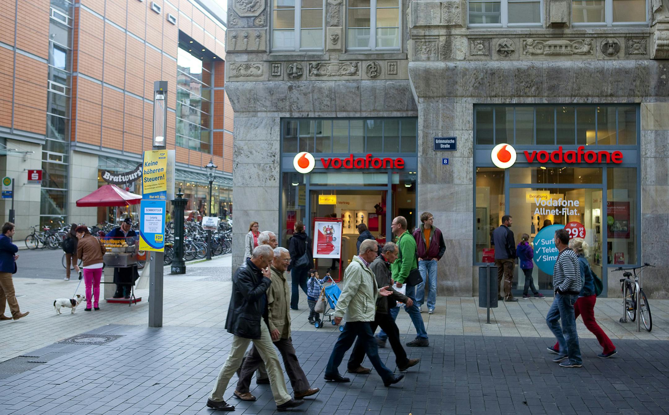 Pedestrians walk past a Vodafone store in Leipzig, Germany. lllustrates GERMANY (category i) by Leon Mangasarian (c) 2014, Bloomberg News. Moved: Saturday, April 5, 2014 (MUST CREDIT: Bloomberg News photo by Krisztian Bocsi).