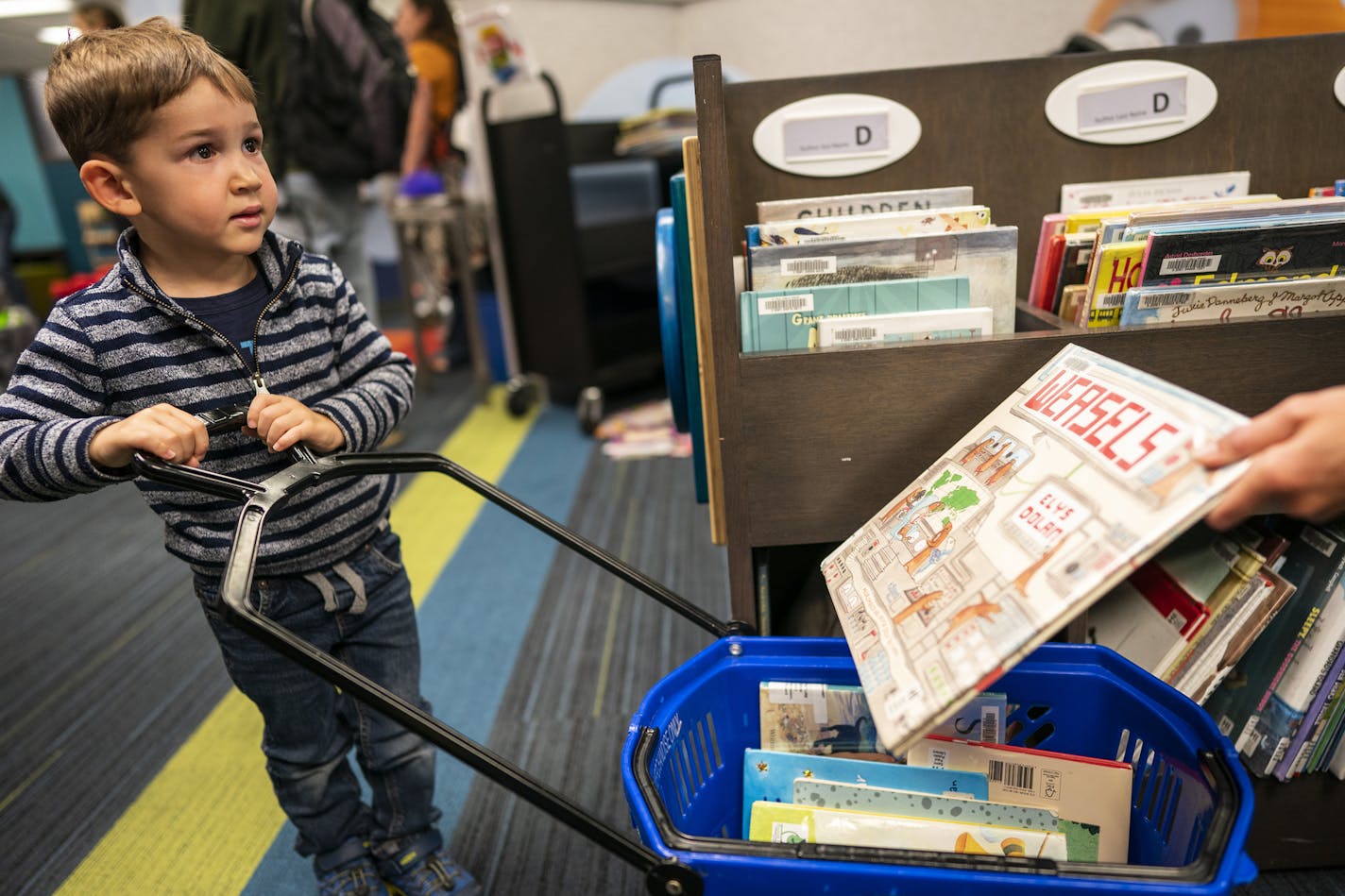 Rory Nelson, 3, pulled a cart of library books to check out of Highland Park Library on Sept. 9.