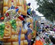 FILE - In this Feb. 11, 2018, file photo, float riders toss beads and trinkets during the Krewe of Thoth Mardi Gras parade in New Orleans. There won't
