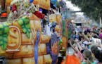 FILE - In this Feb. 11, 2018, file photo, float riders toss beads and trinkets during the Krewe of Thoth Mardi Gras parade in New Orleans. There won't