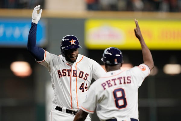 Astros DH Yordan Alvarez greets third base coach Gary Pettis after hitting the second of his two home runs during Game 1 of an American League Divisio