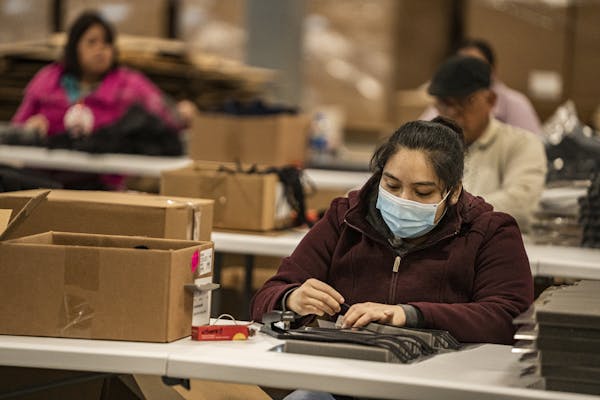 Perla Hernandez helps assemble a face shield, most likely headed to a health care worker.] John Schwanke's family-owned manufacturing business in Carv
