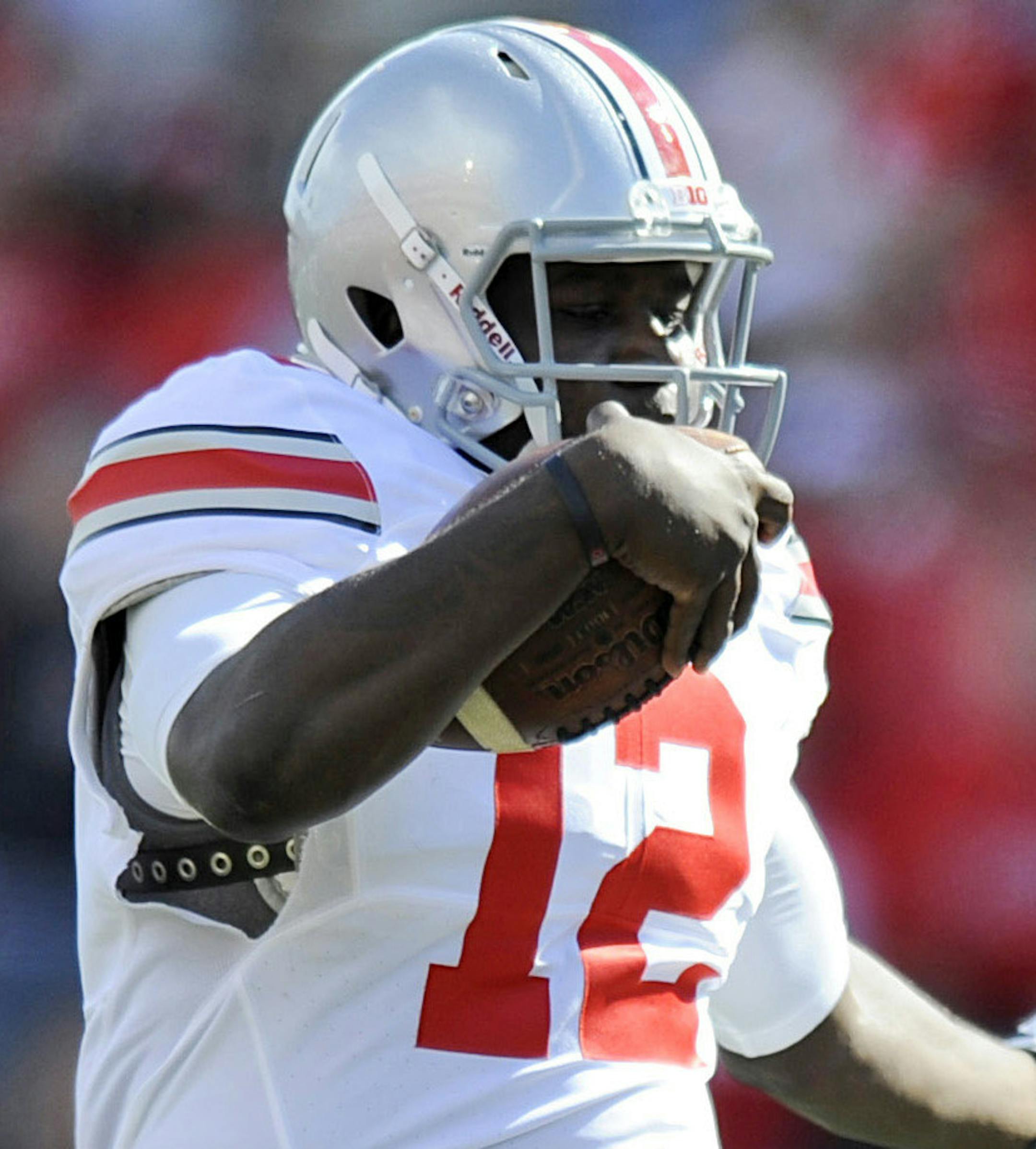 FILE - In this Oct. 4, 2014, file photo, Ohio State's quarterback Cardale Jones leaps over Maryland's safety Anthony Nixon during the second half of an NCAA college football game in College Park, Md. After Ohio State lost quarterback Braxton Miller in the preseason to a shoulder injury, J.T. Barrett had a big year before breaking his ankle against Michigan. Now the Buckeyes turn to Cardale Jones in the Big Ten title game against Wisconsin on Saturday, Dec. 6, 2014. (AP Photo/Gail Burton, File)