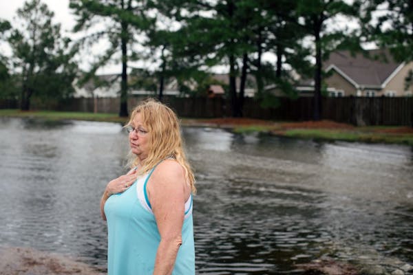 Cindy Caster surveys the floodwaters inundating her neighborhood in Wilmington, N.C.