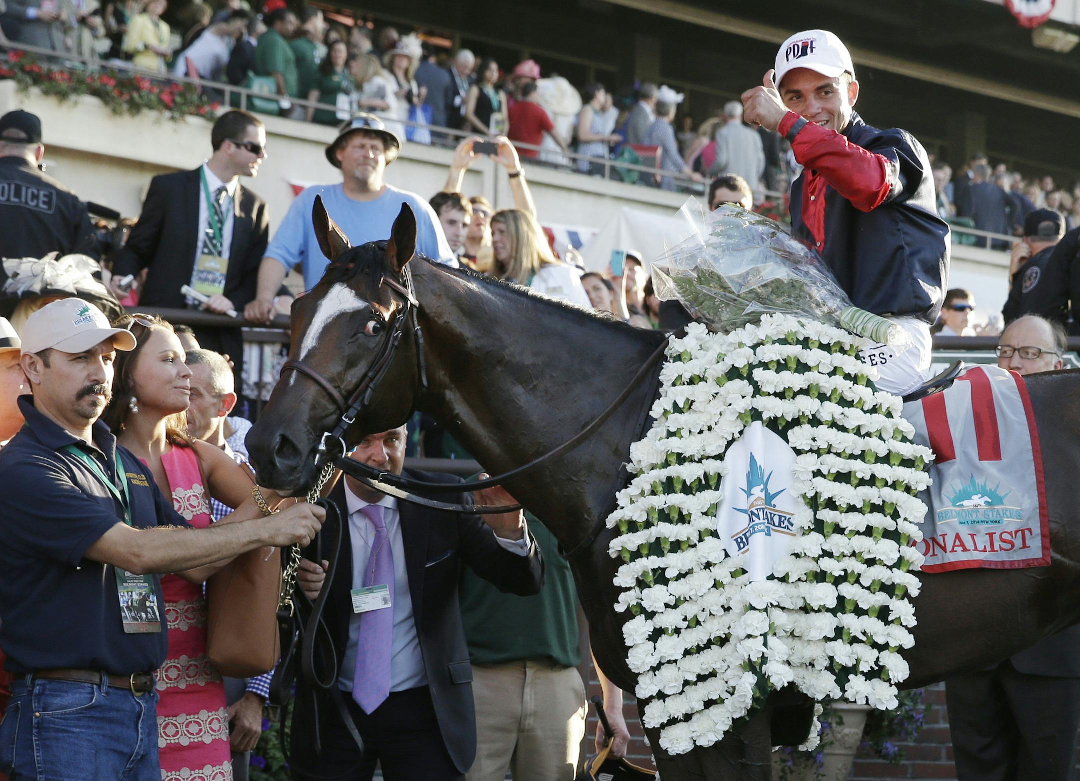 Joel Rosario poses for photos atop Tonalist after winning the 146th running of the Belmont Stakes horse race, Saturday, June 7, 2014, in Elmont, N.Y. (AP Photo/Seth Wenig)