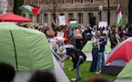 Pro-Palestinian demonstrators set up tents on the lawn south of Northrop auditorium at the University of Minnesota in Minneapolis on Monday. A few hun