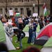 Pro-Palestinian demonstrators set up tents on the lawn south of Northrop auditorium at the University of Minnesota in Minneapolis on Monday. A few hun